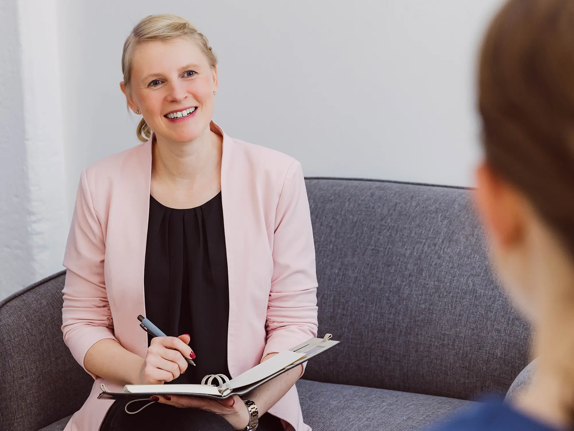 Nicole zuhörend und lächelnd während Coachingsitzung